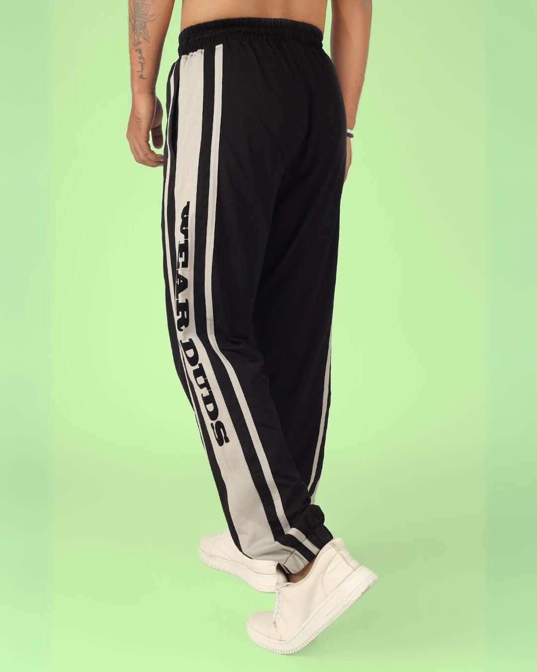 Model wearing DUDS HD Contrast Panel Joggers in black and grey with white sneakers.