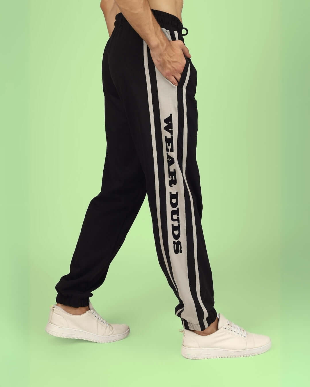 Black and grey DUDS HD contrast panel joggers with white sneakers, featuring "Wear DUDS" text on the side.