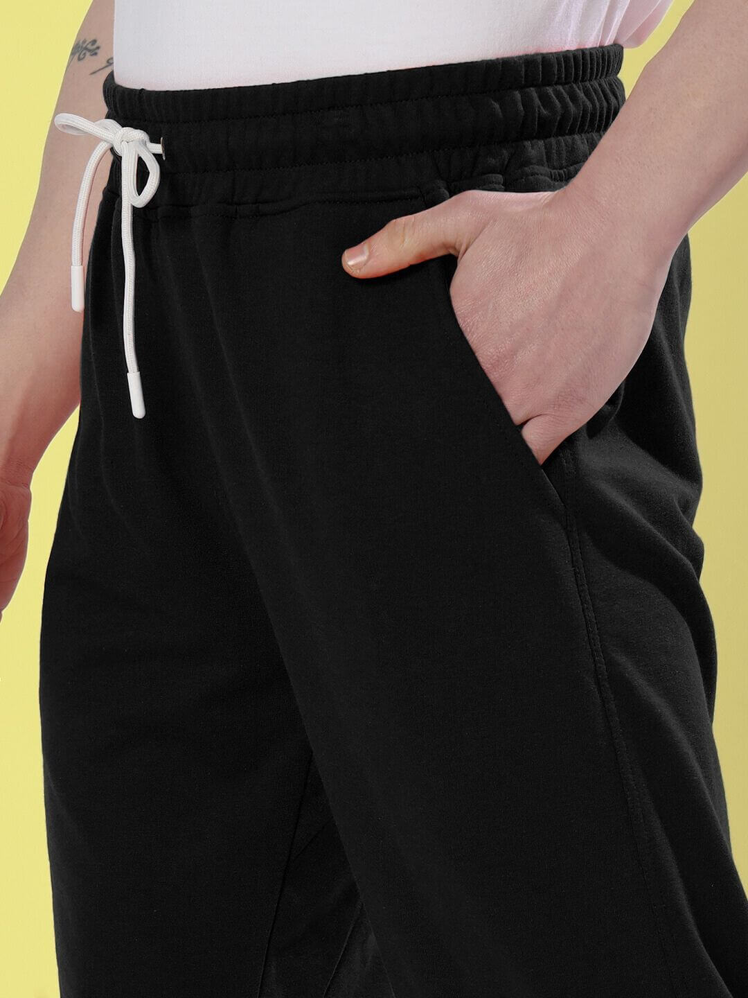 Close-up of black DUDS limited edition jogger showcasing elastic waistband and hand in pocket, made to order for perfect customization.