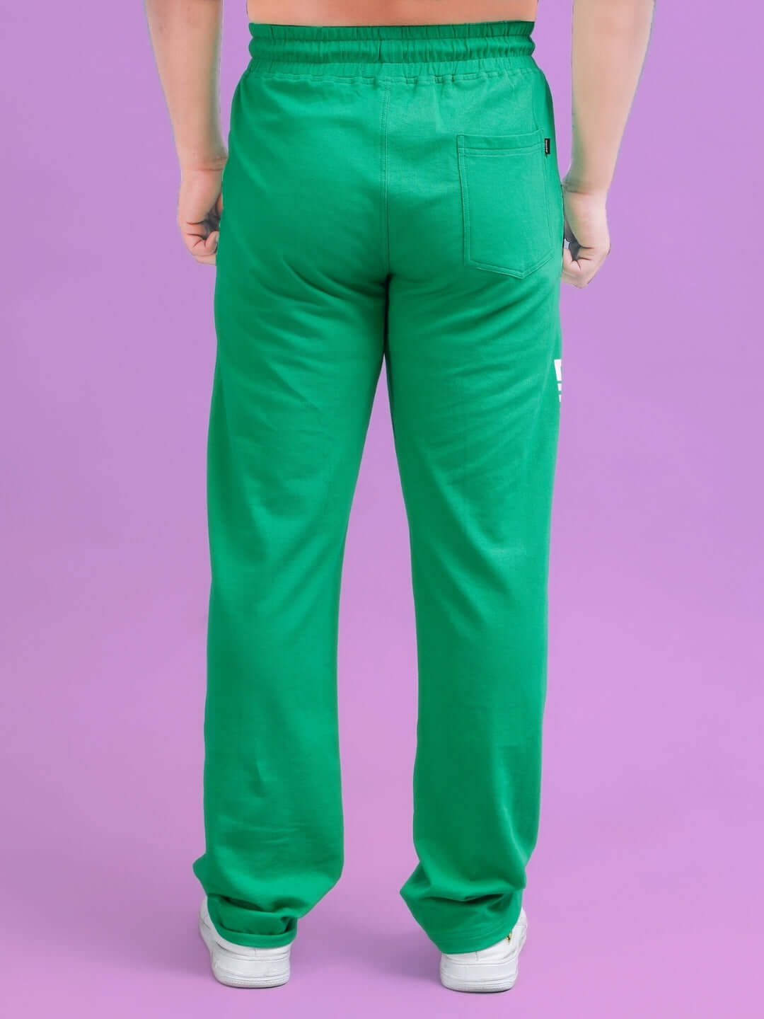Back view of green DUDS Limited Edition Jogger, showcasing tailored fit and rear pocket, on a purple backdrop.
