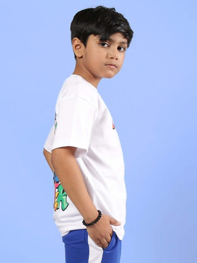 Boy wearing DUDS MONSTER T-SHIRT FOR BOYS & GIRLS WHITE against blue background