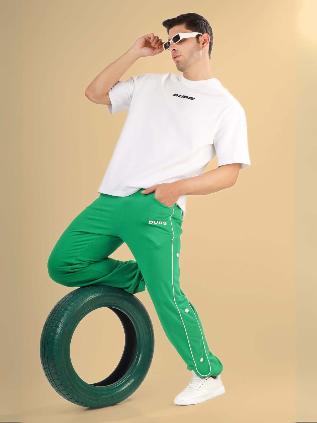 Model wearing DUDS MOON NIGHT JOGGERS in green, paired with a white t-shirt, showcasing casual fashion style with a sporty touch.