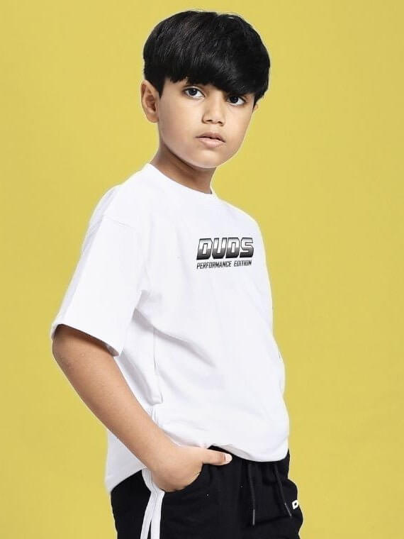 Boy wearing DUDS PERFORMANCE T-SHIRT FOR BOYS AND GIRLS WHITE against yellow background