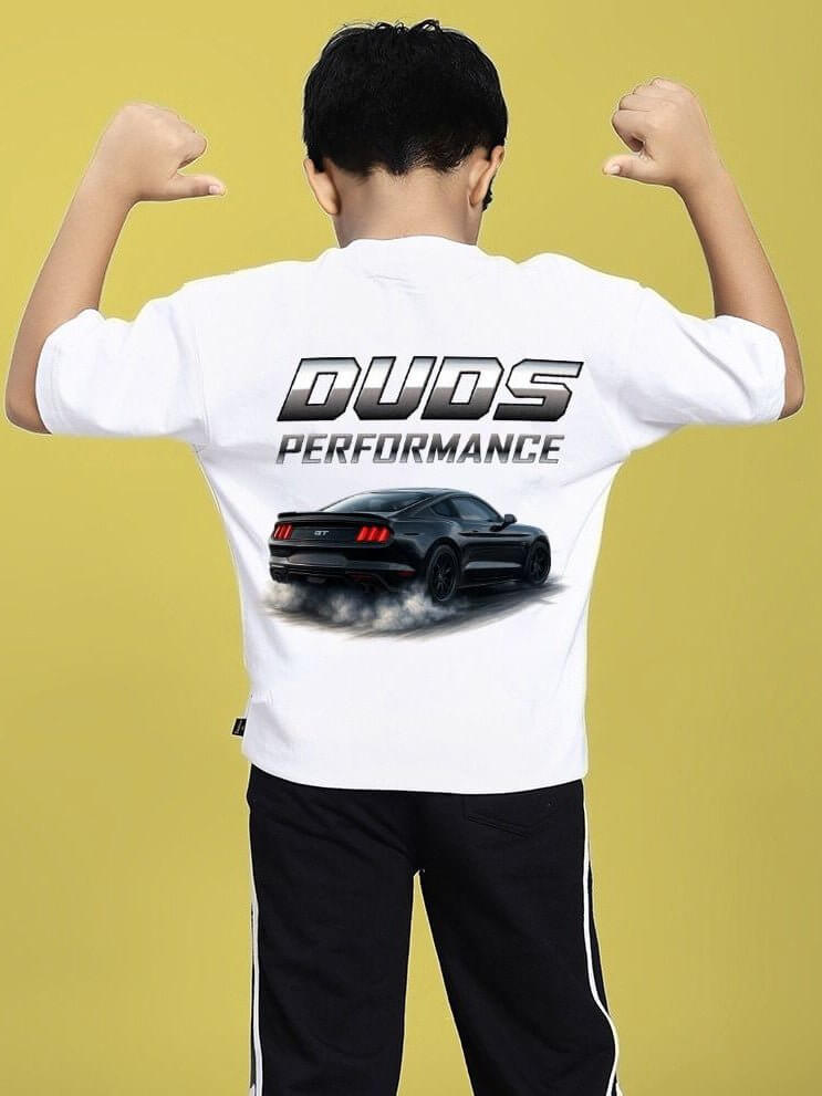 Boy wearing DUDS PERFORMANCE T-SHIRT FOR BOYS AND GIRLS WHITE with car print on back, showcasing sporty style and comfort for active kids.