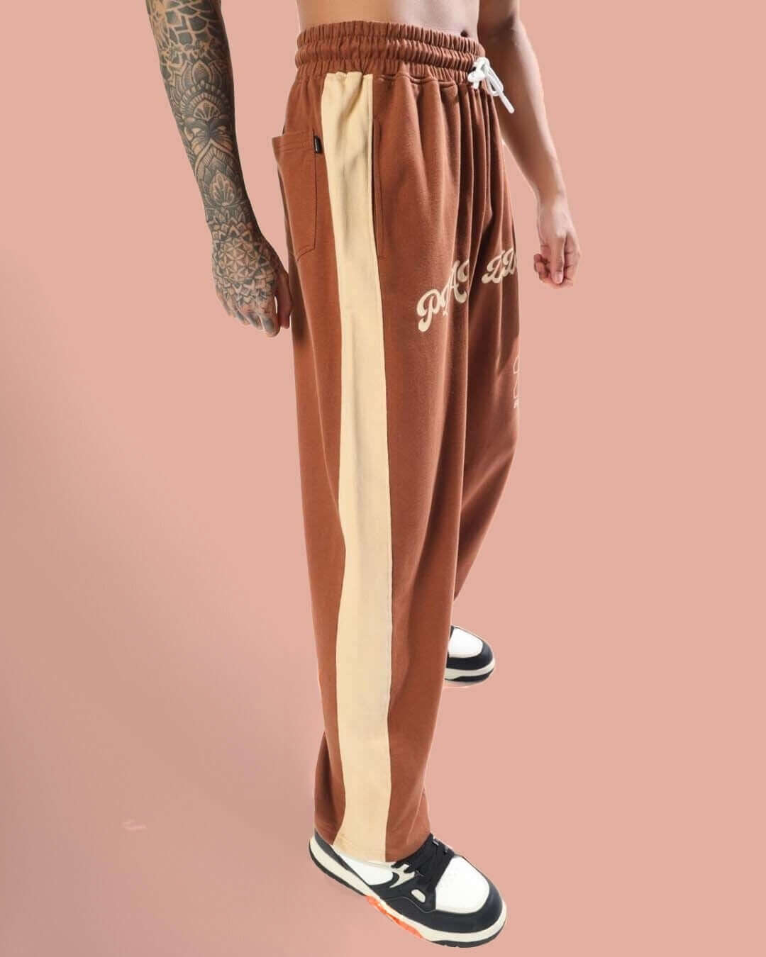 Brown-beige baggy joggers with side stripe detail, featuring customizable fit and made-to-order options from DUDS.