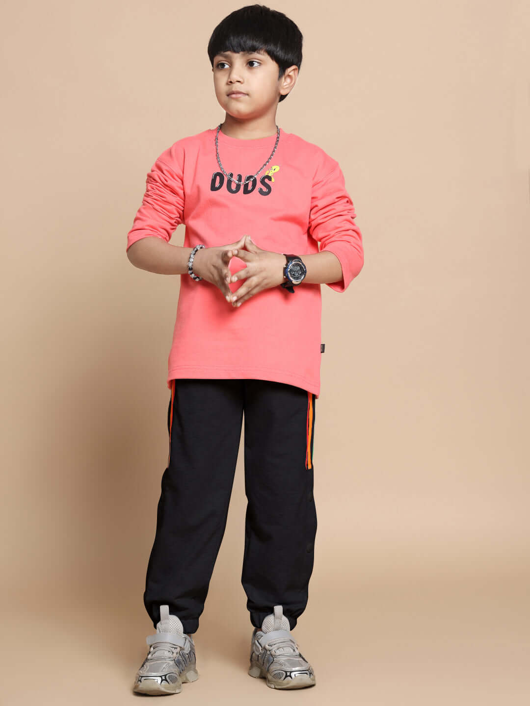Young model wearing DUDS Prism Colorful Stripe Jogger, black with orange stripes, perfect for boys and girls, showcasing casual style.