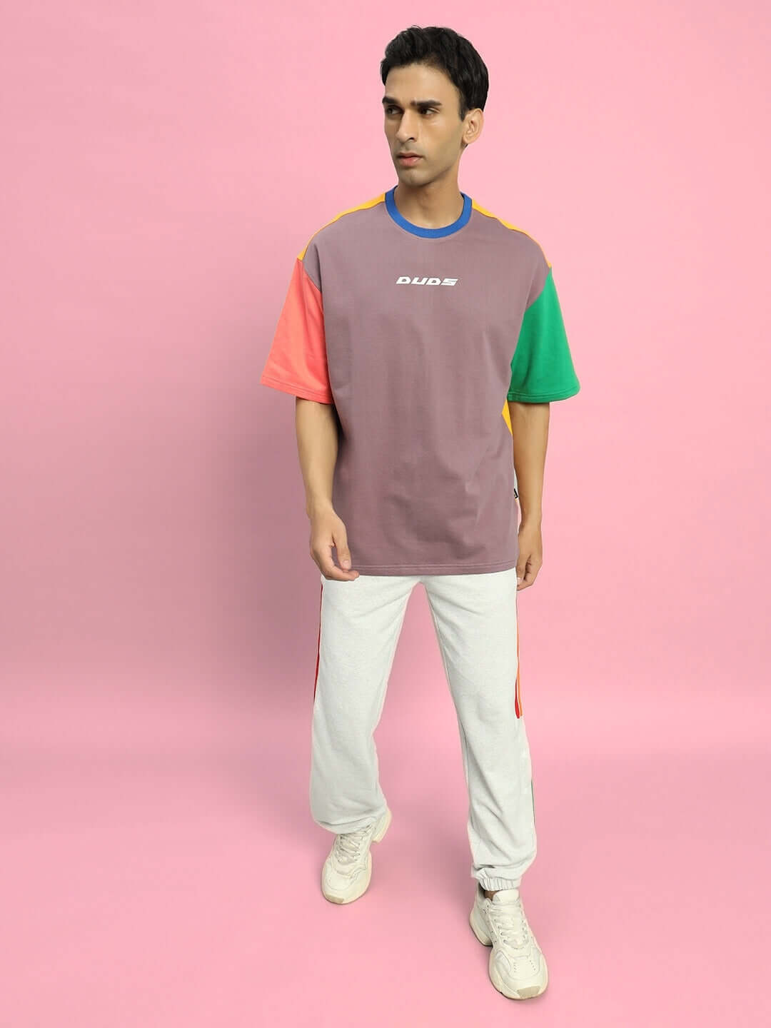 Man wearing DUDS PRISM colorful stripe joggers in melange grey on a pink background.