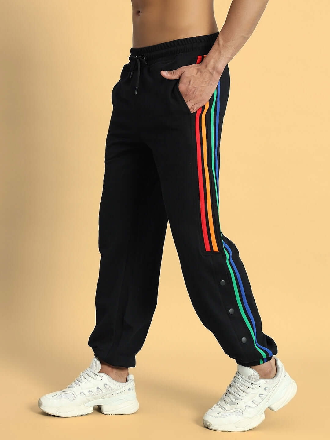 Model wearing black joggers with colorful stripes, showcasing DUDS PRISM's stylish design. Custom fit available for prepaid orders.