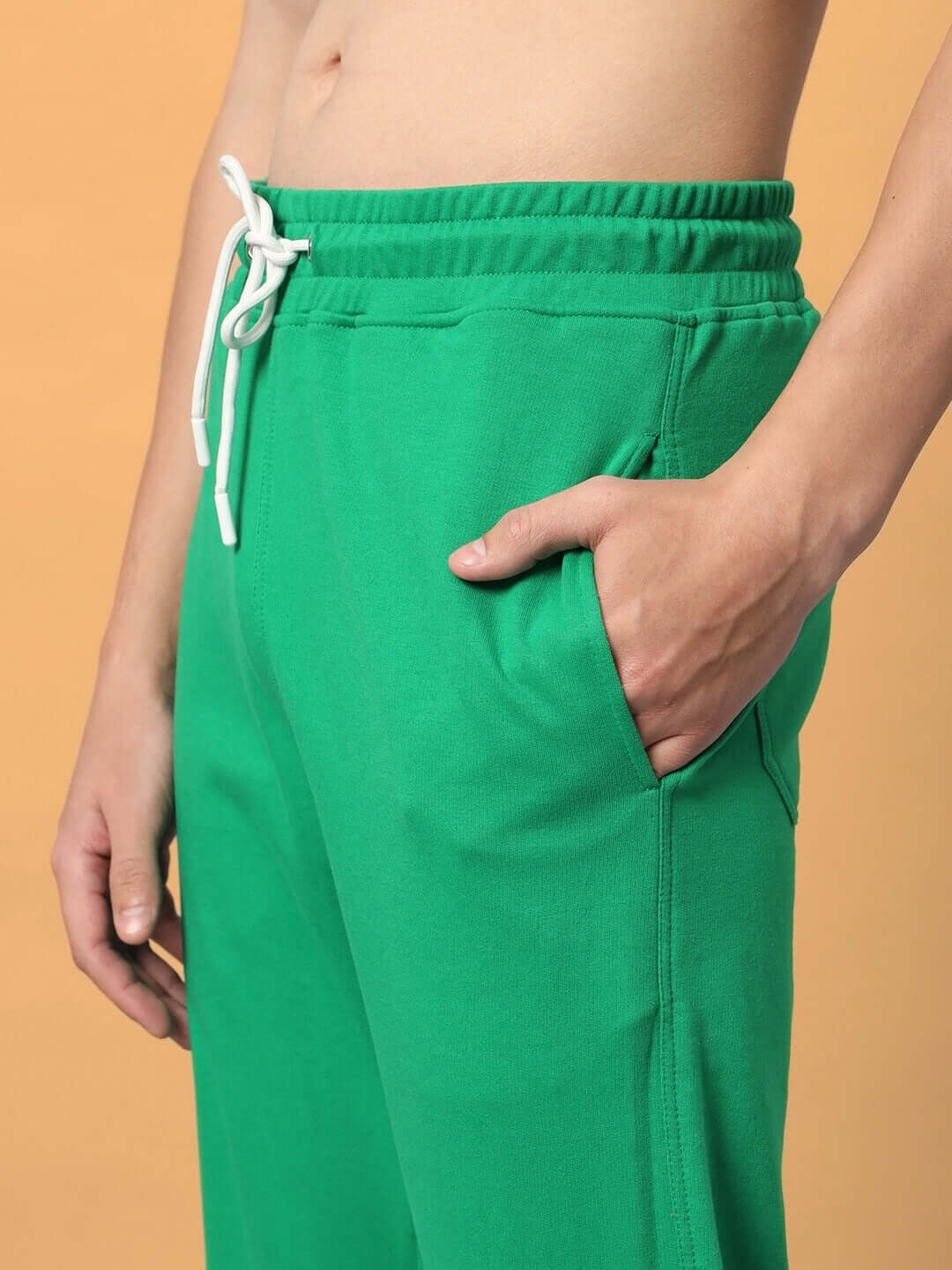 Model wearing green DUDS Racer Joggers with drawstring waist, showcasing custom fit and comfort.