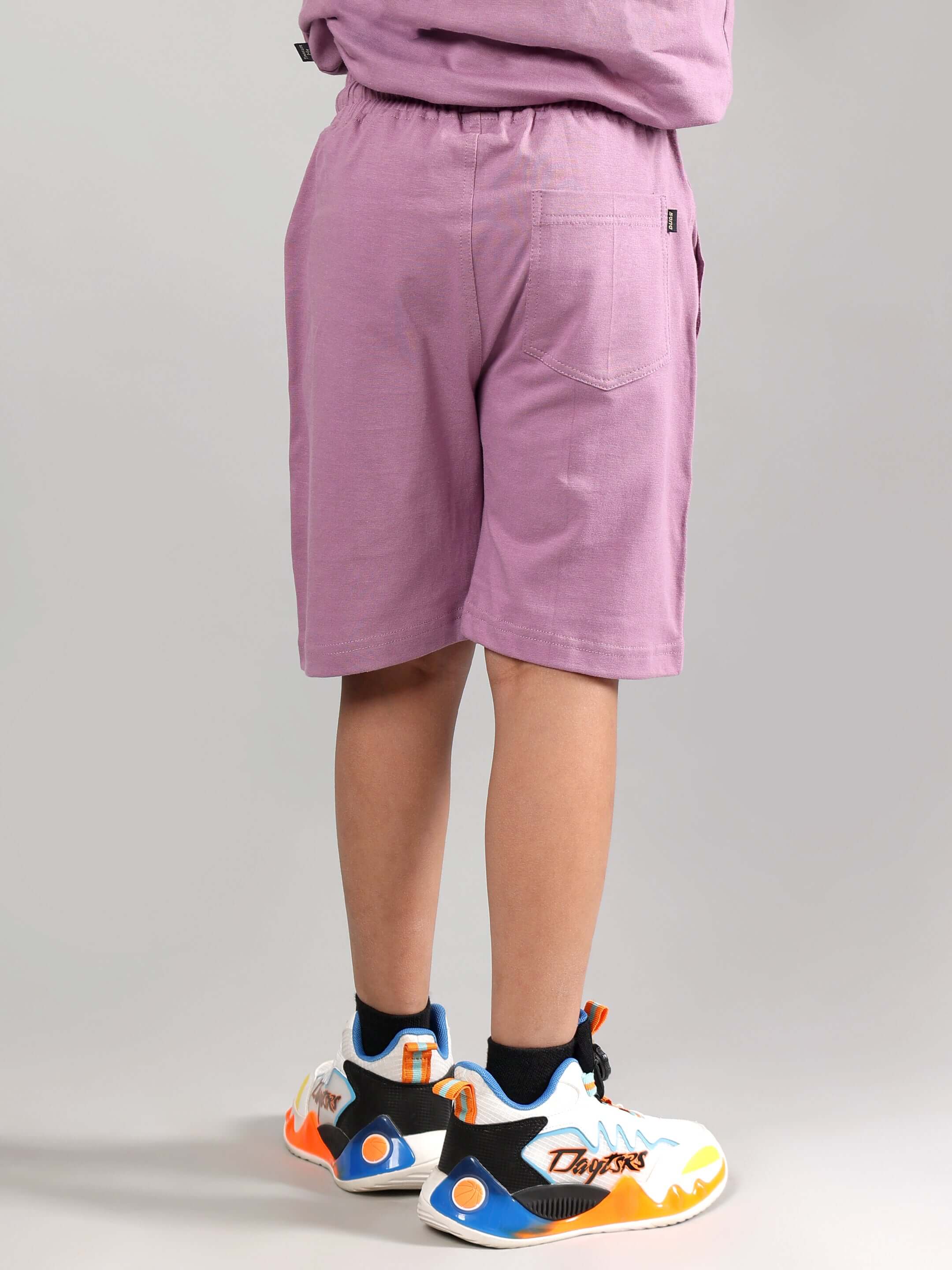 Child wearing DUDS Street Co-Ord in Plum Purple with colorful sneakers, showcasing back view and casual fit.