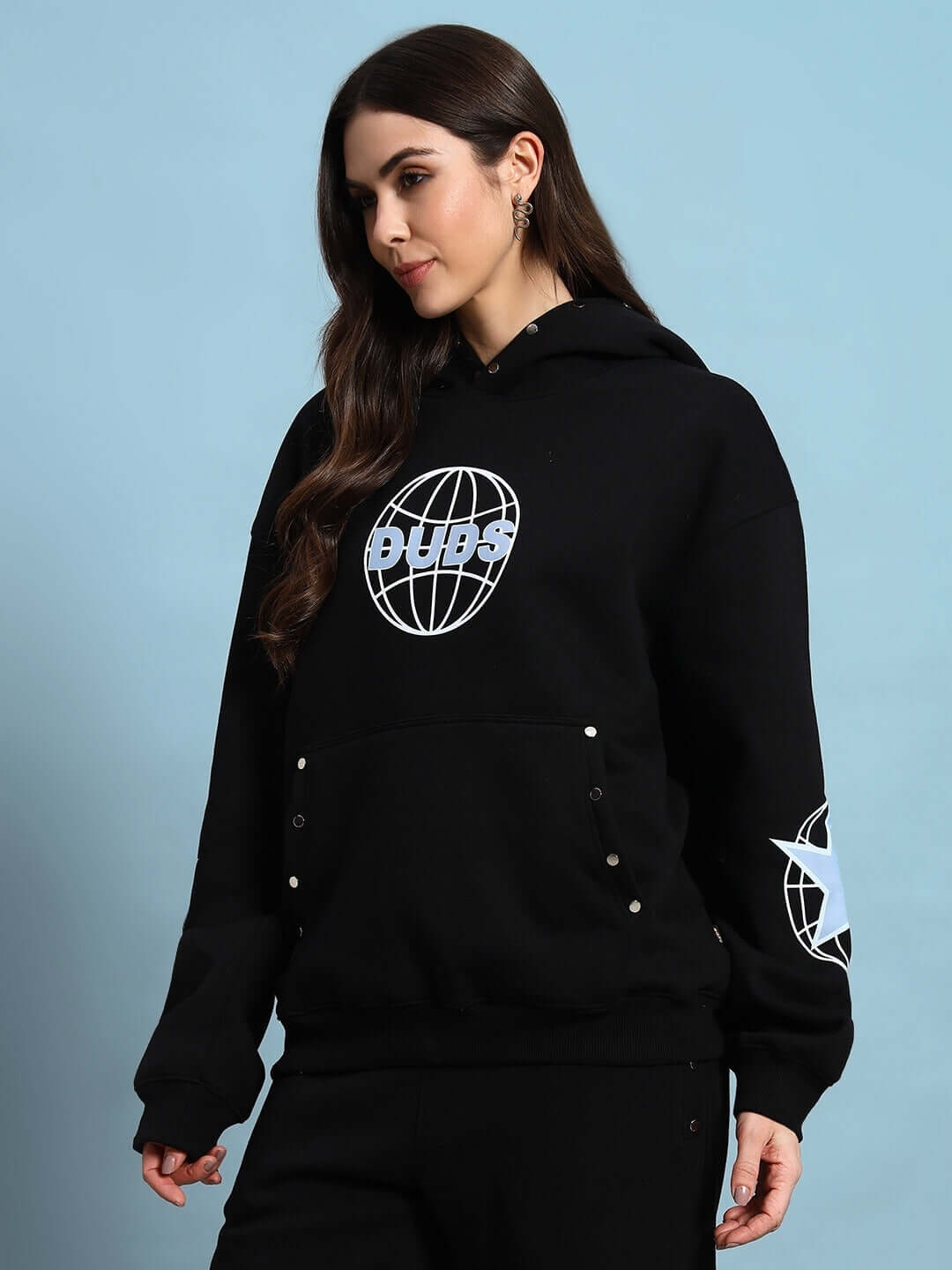 Woman wearing WOMEN GLOBAL FLEECE HOODIE BLACK with globe design and kangaroo pocket