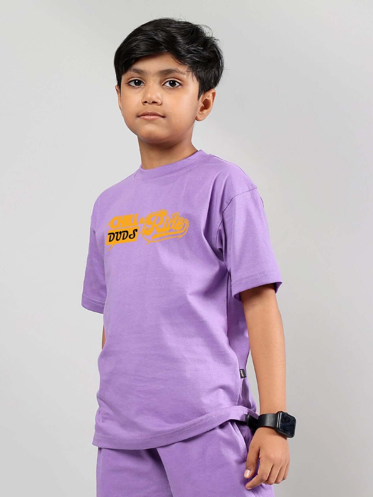 Young child wearing a DUDS Chill & Ride lavender t-shirt for boys and girls, showcasing casual style.