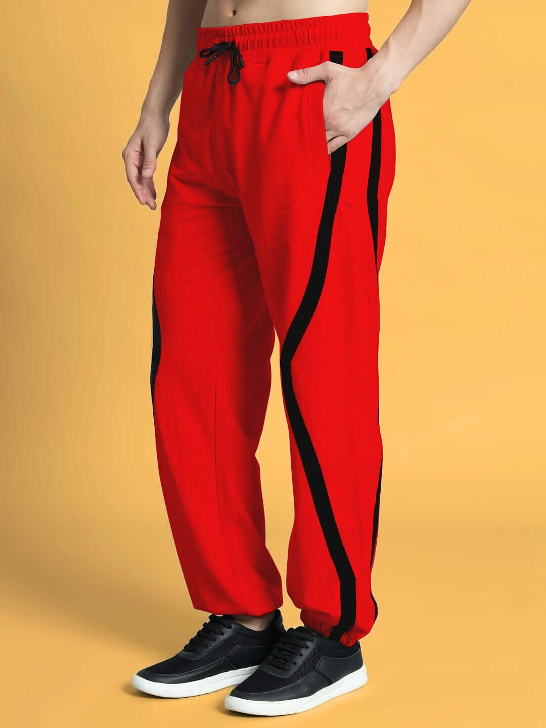 Model wearing DUDS FRAME Joggers in red with black stripe detail; customizable fit available for prepaid orders; 7-10 day dispatch.