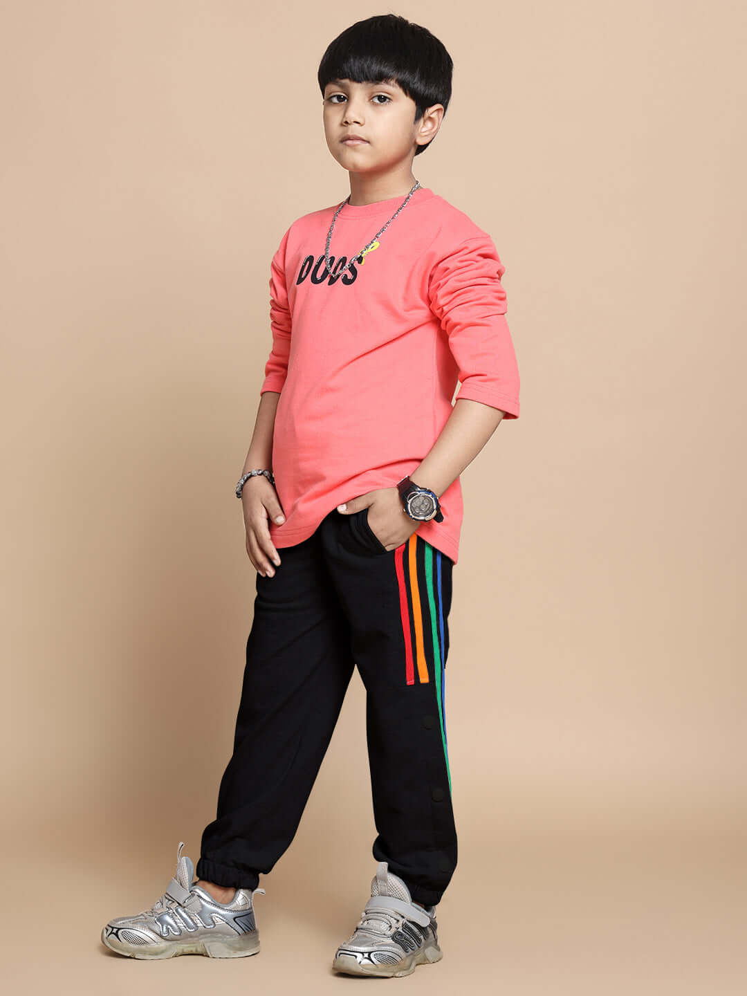 Child wearing DUDS Prism Colorful Stripe Jogger in black, featuring vibrant side stripes, styled with a casual pink top.