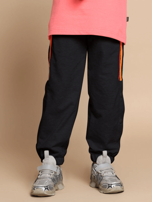 Black jogger pants with colorful stripes for kids, featuring a comfortable fit, perfect for both boys and girls, by DUDS.