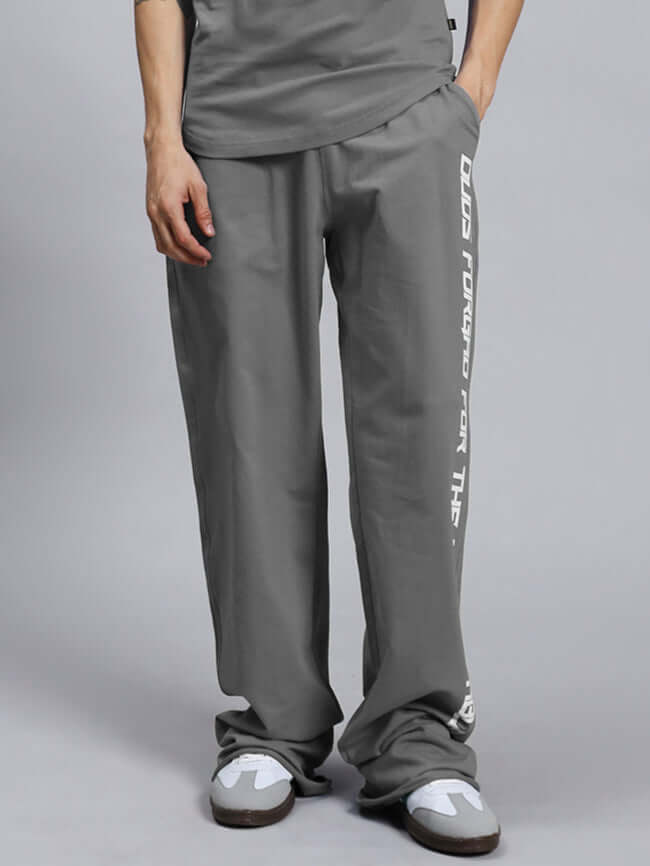 Person wearing DUDS SWIFT JOGGER COTTON TERRY GREY with graphic on side, showcasing comfortable and stylish fit.