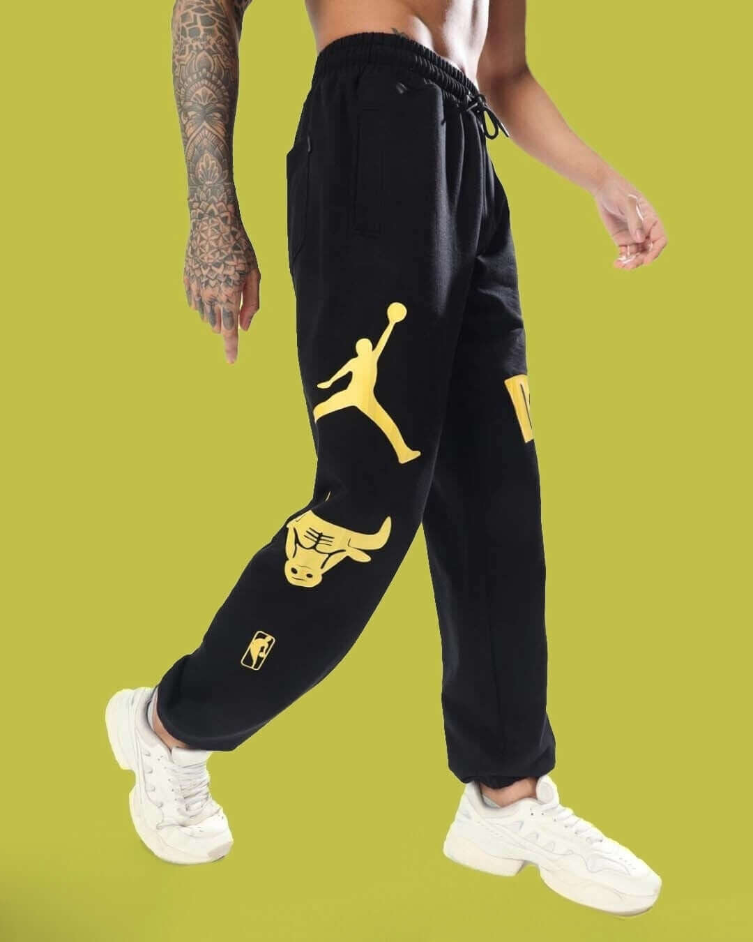 Model wearing black Duke Relaxed Pant Jogger with yellow graphics, showcasing side view and design details.