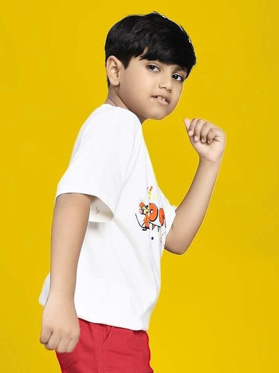 Young boy wearing DUMBO T-SHIRT FOR BOYS AND GIRLS WHITE on a yellow background.