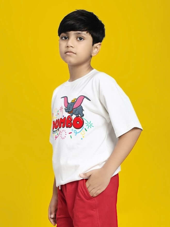 Child wearing DUMBO T-SHIRT FOR BOYS AND GIRLS WHITE standing against yellow background