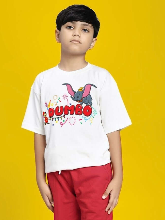 Boy wearing DUMBO T-SHIRT FOR BOYS AND GIRLS WHITE with colorful Dumbo graphic on yellow background.