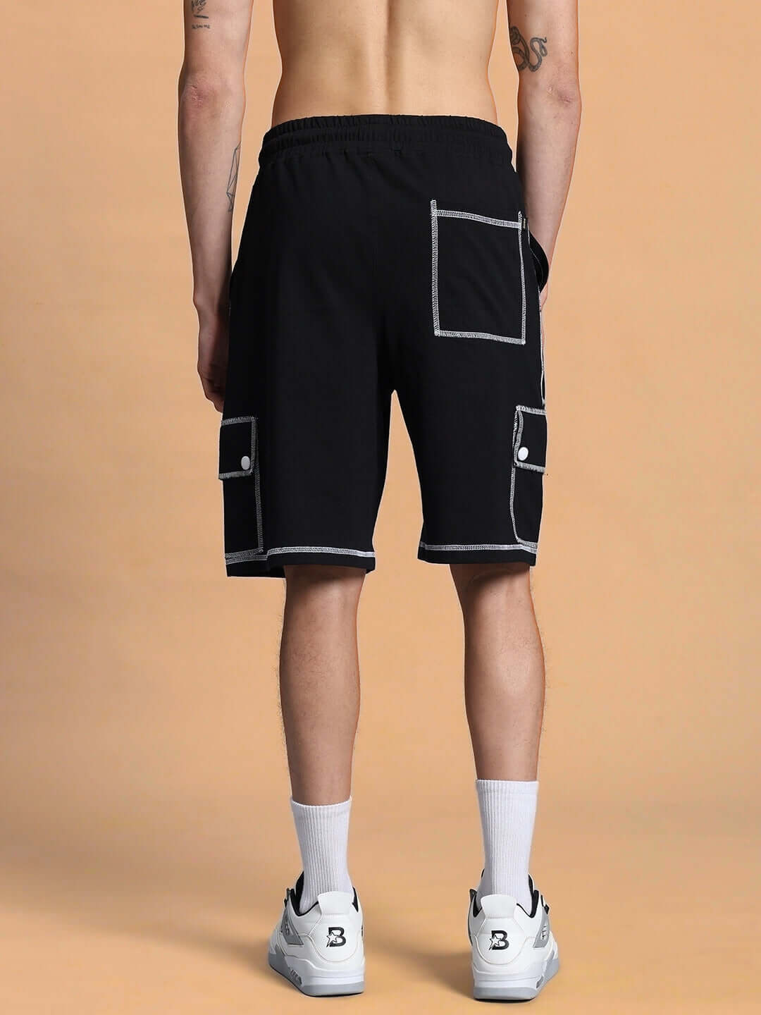 Back view of DYNAMIC REGULAR FIT SHORTS BLACK worn by model, showcasing pocket details, unisex design, and comfortable fit.