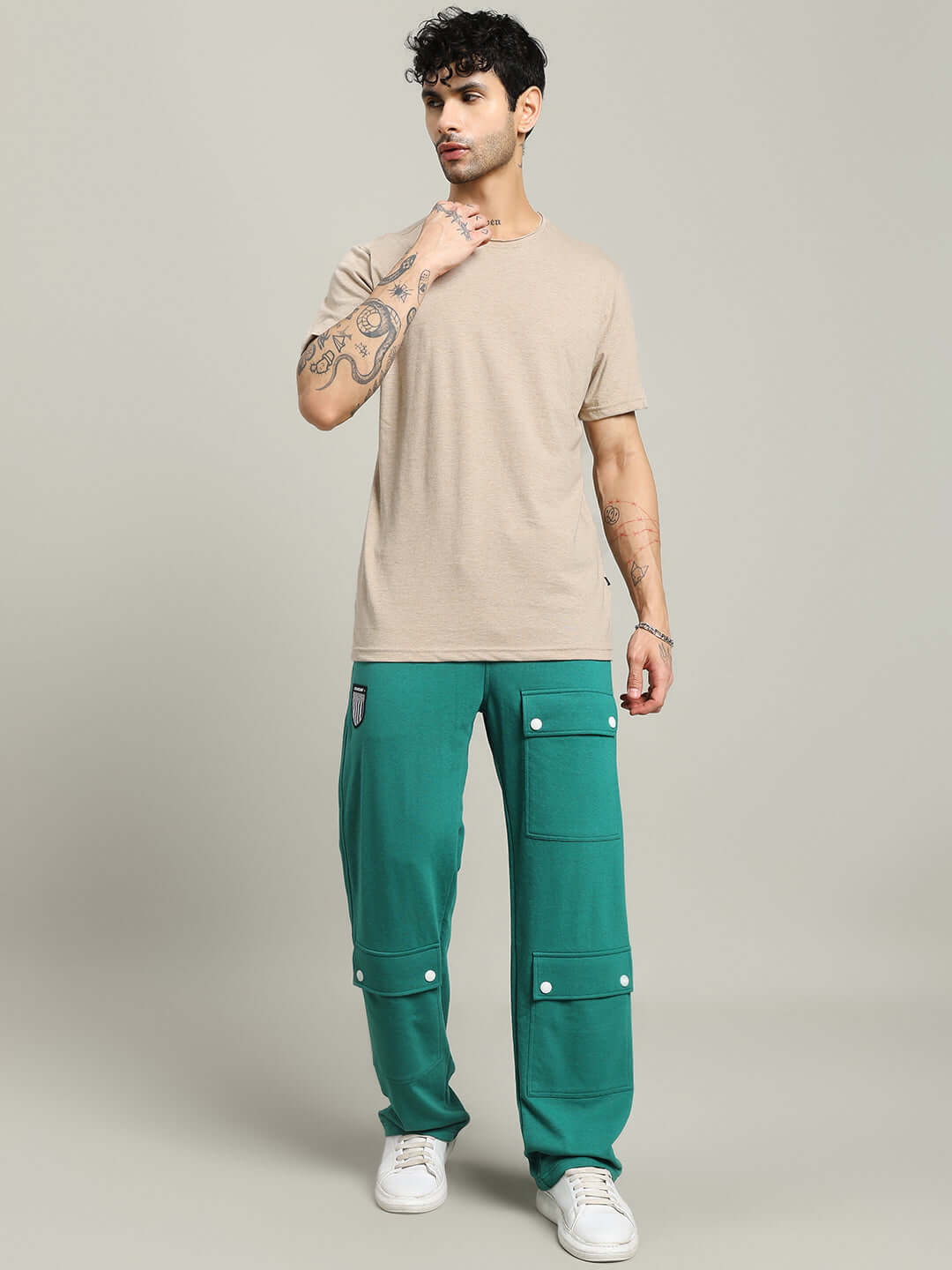 Man wearing ELEX REGULAR FIT T-SHIRT BEIGE with green pants and white sneakers
