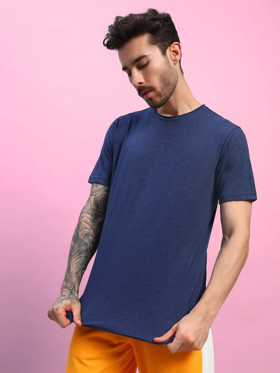 Man wearing ELEX REGULAR FIT T-SHIRT NAVY BLUE against pink background