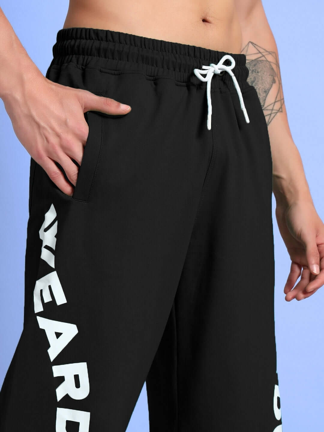 Model wearing ELLEN RELAXED FIT JOGGER BLACK with white drawstrings, showcasing the side pocket design and bold lettering.