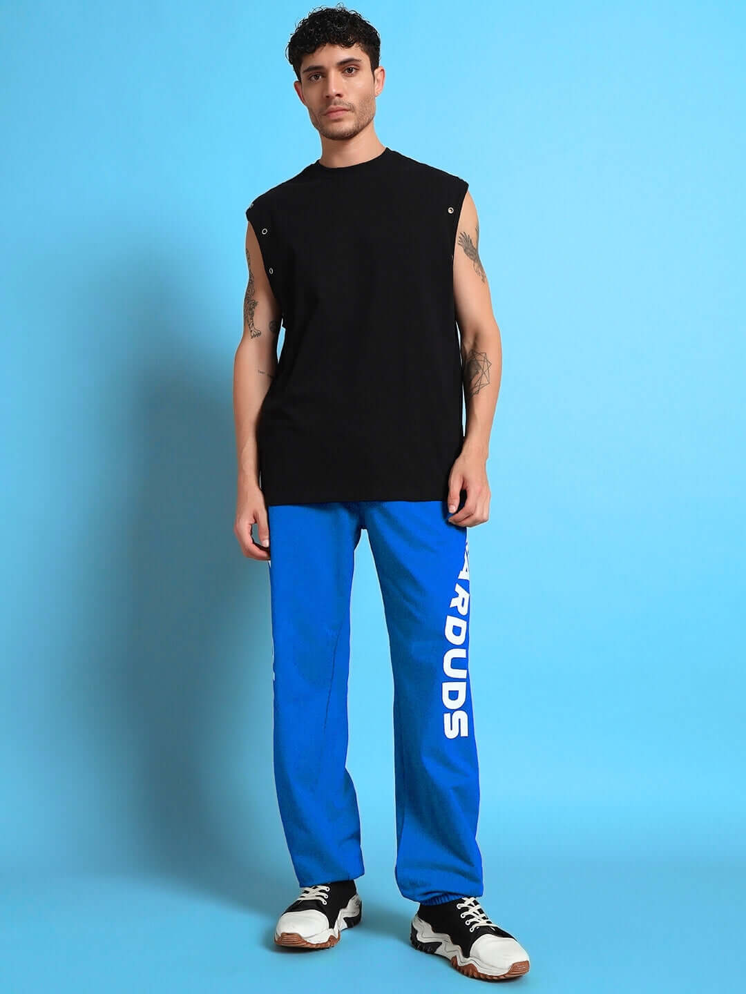 Man wearing ELLEN RELAXED FIT JOGGER BLUE with logo, showcasing casual streetwear style.