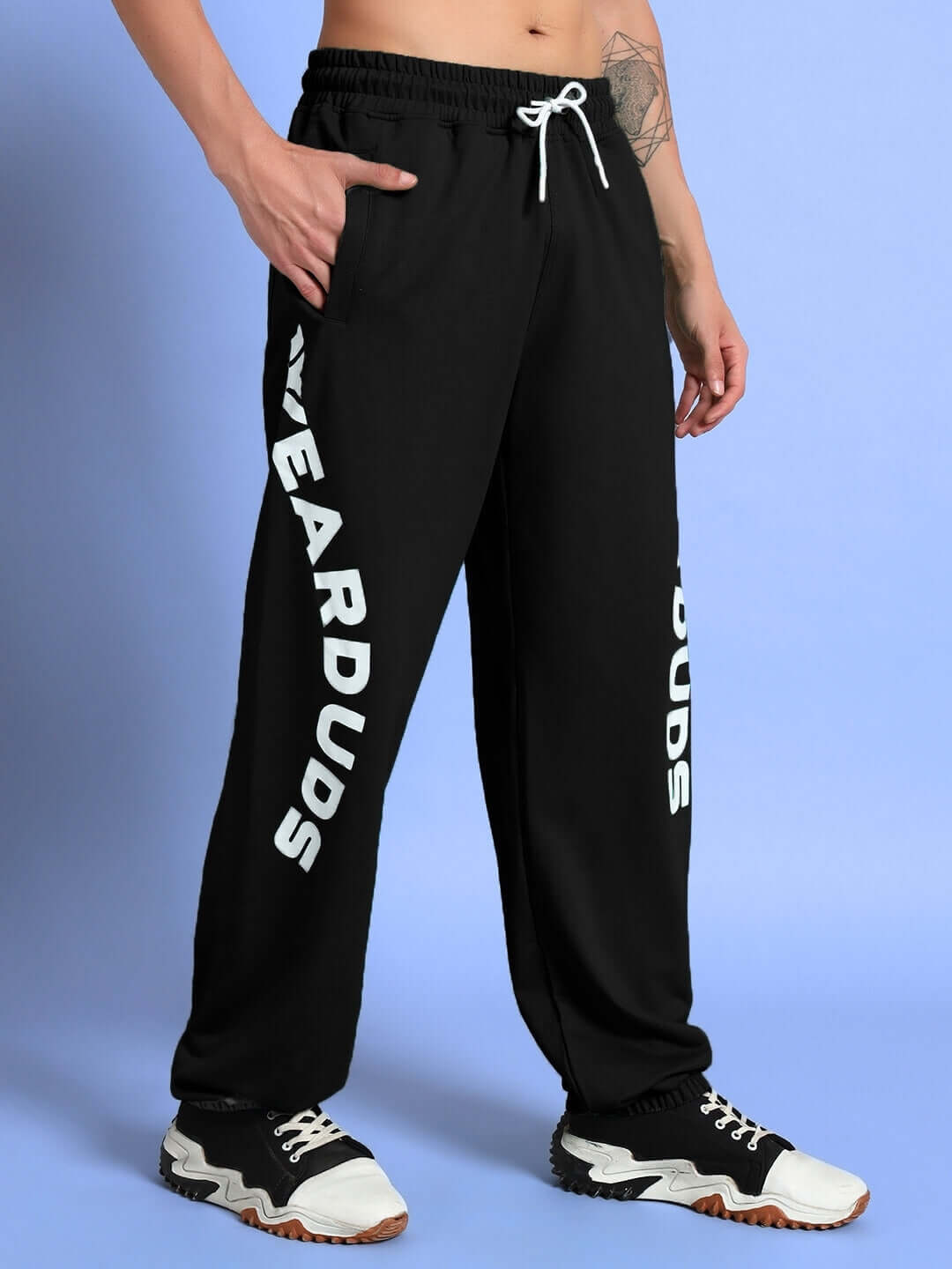 Model wearing ELLEN RELAXED FIT JOGGER BLACK with stylish lettering on the side, showcasing comfortable and versatile streetwear.