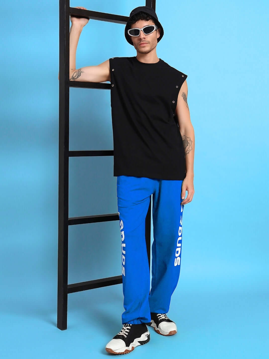 Model wearing ELLEN RELAXED FIT JOGGER BLUE showcasing stylish streetwear look against a blue background
