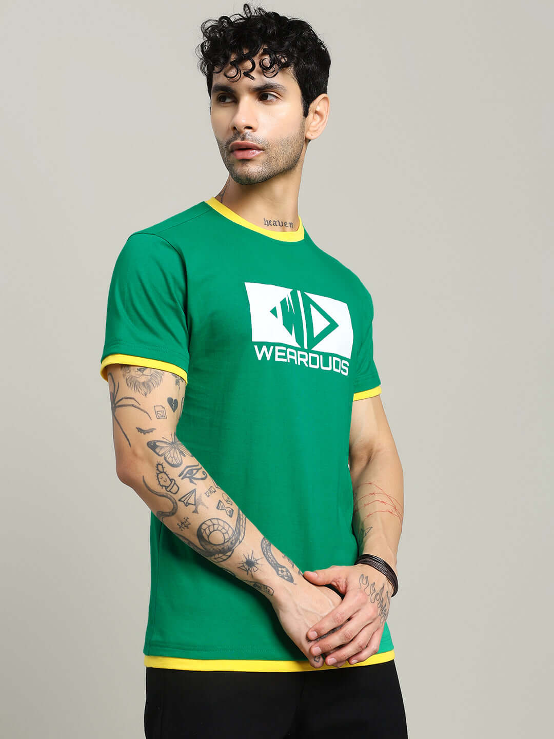 Man wearing ELMER REGULAR FIT T-SHIRT GREEN with tattoos, showcasing premium cotton fabric and versatile style.