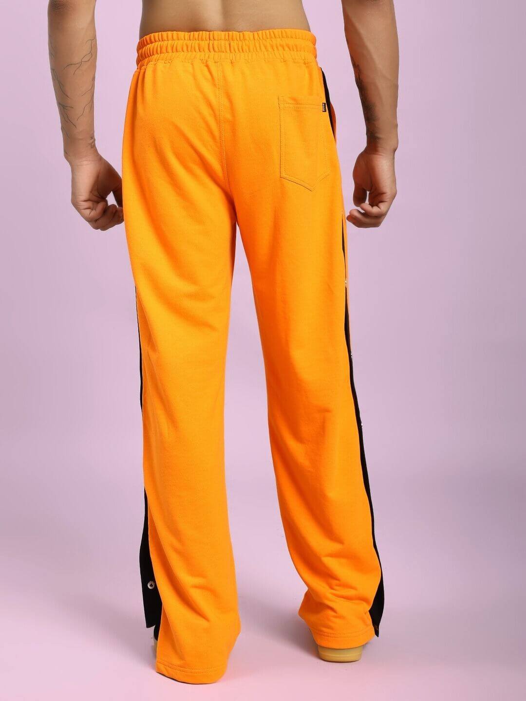 Model wearing EMBER BOLT SIDE JOGGER IN ORANGE with sleek side stripes, vibrant and comfortable casual wear for style and comfort.