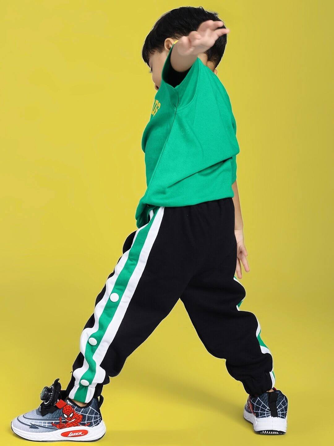 Child wearing EMIRATI JOGGER FOR BOYS AND GIRLS BLACK GREEN with stylish green accents.