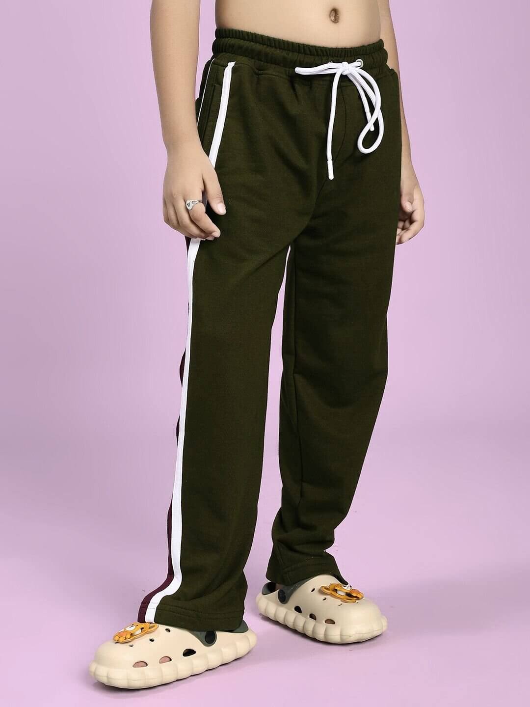 Child wearing EPIC DINO CO-ORD FOR BOYS GIRLS OLIVE GREEN pants, showcasing playful dinosaur style with white side stripes.