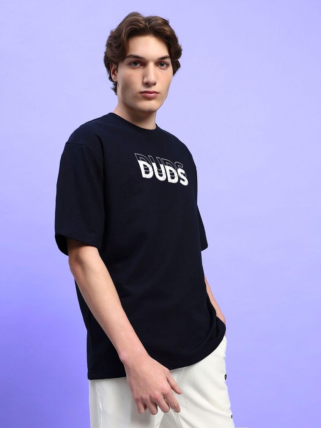 Person wearing an EVERYTHING IS TEMPORARY OVER-SIZED T-SHIRT BLACK against a purple background