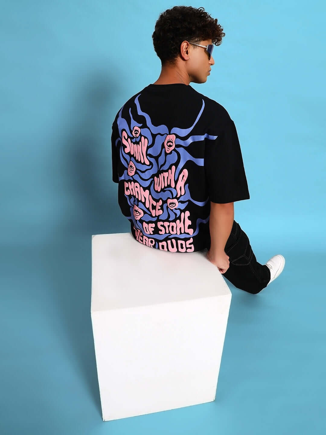 Model wearing EYE BALL PUFF PRINT OVER-SIZED T-SHIRT BLACK with puff print design for streetwear fashion.