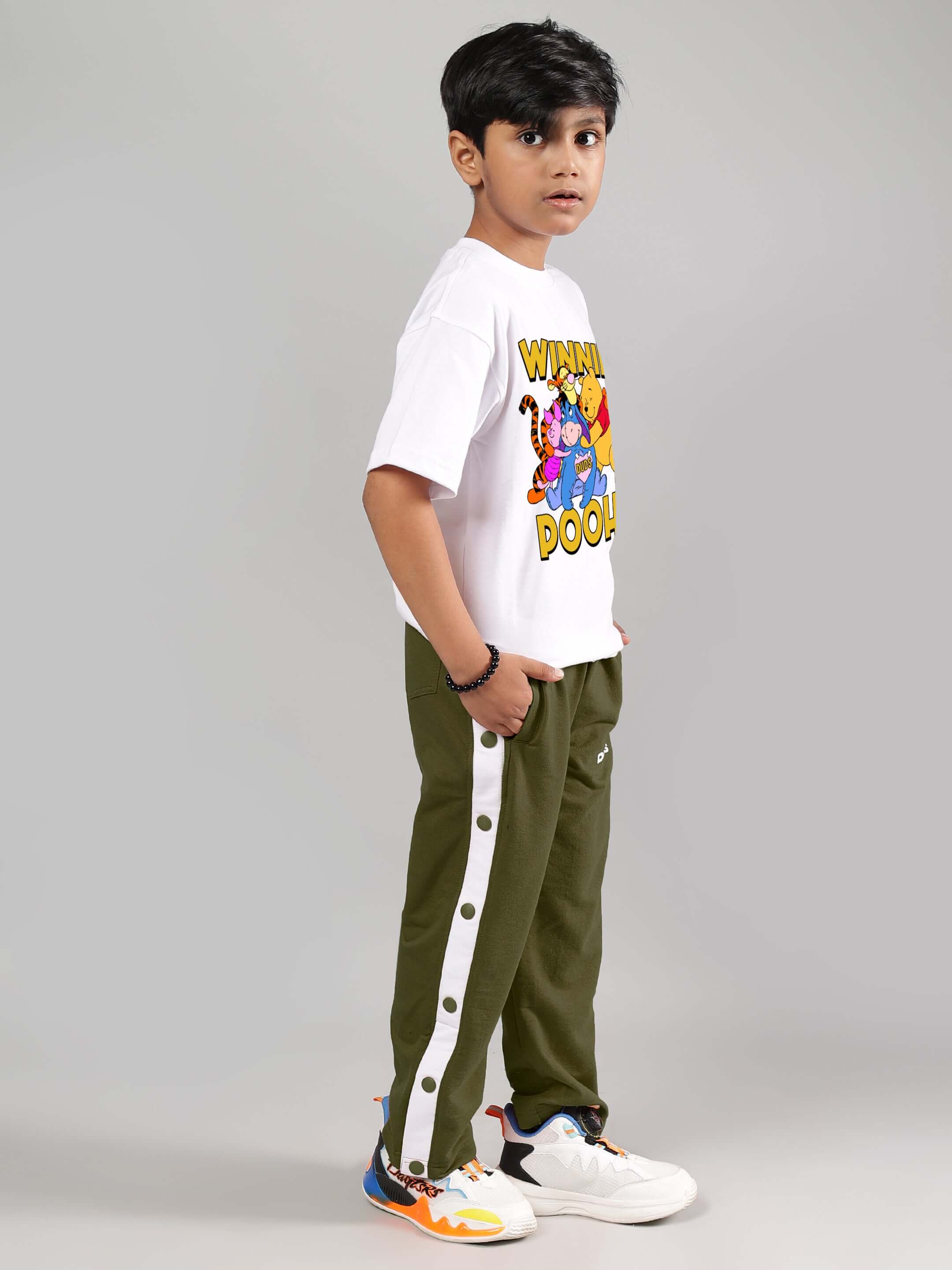Child wearing EZEL JOGGER FOR BOYS & GIRLS OLIVE GREEN, styled with a graphic tee and sneakers.