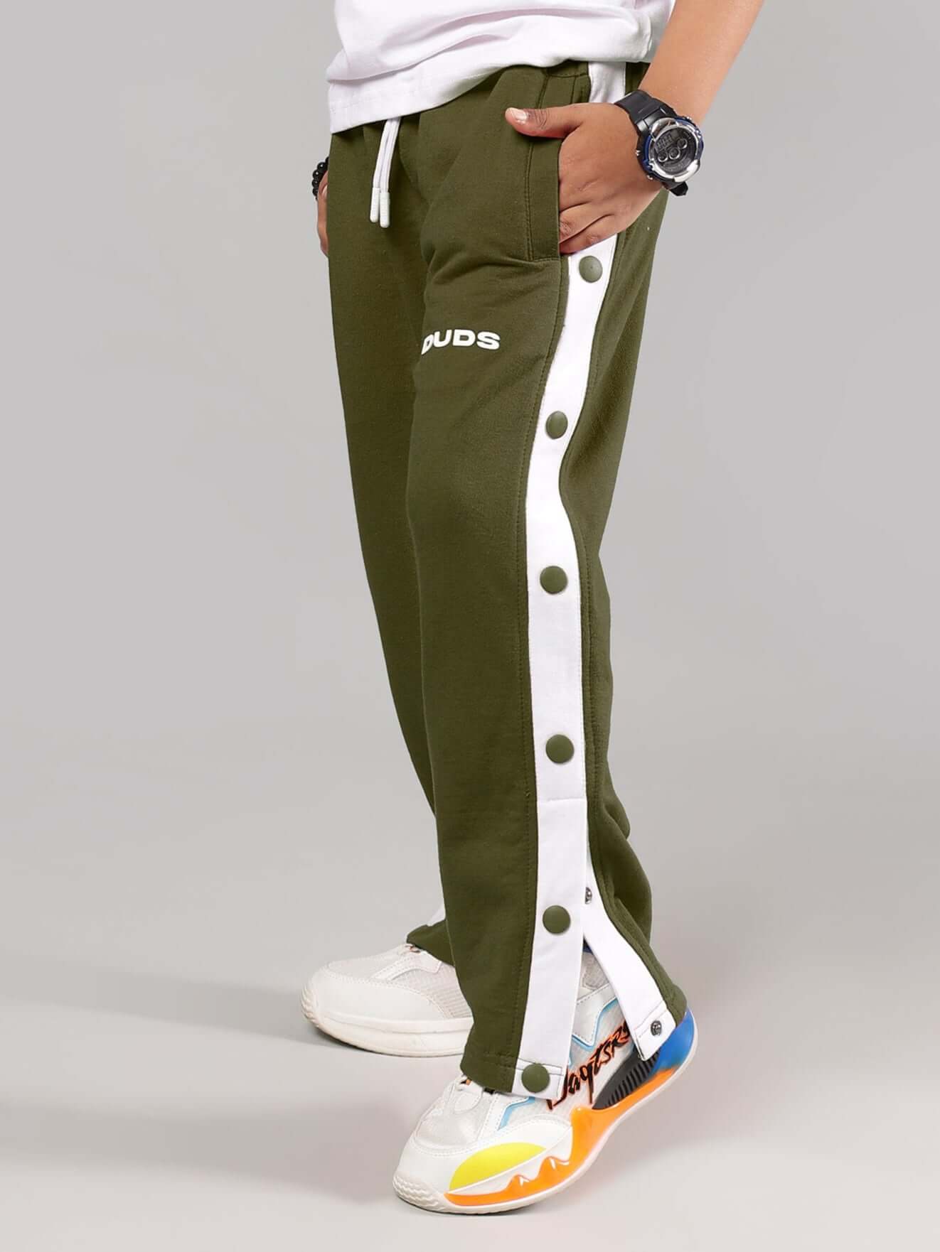 Child wearing EZEL JOGGER FOR BOYS & GIRLS OLIVE GREEN with white stripe detail, showcasing comfortable fit and style.
