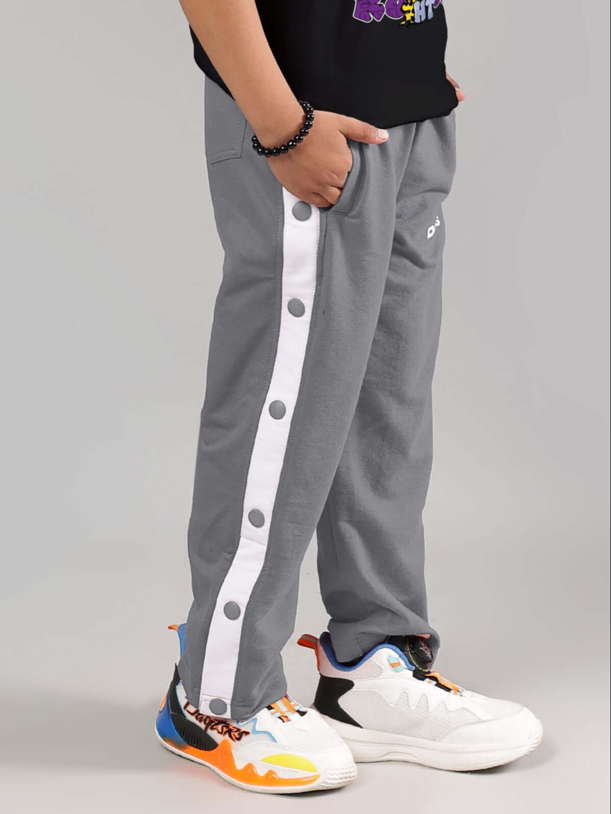 EZEL JOGGER FOR BOYS & GIRLS GREY with side button design, suitable for custom fit and made-to-order, shown on model with colorful sneakers.