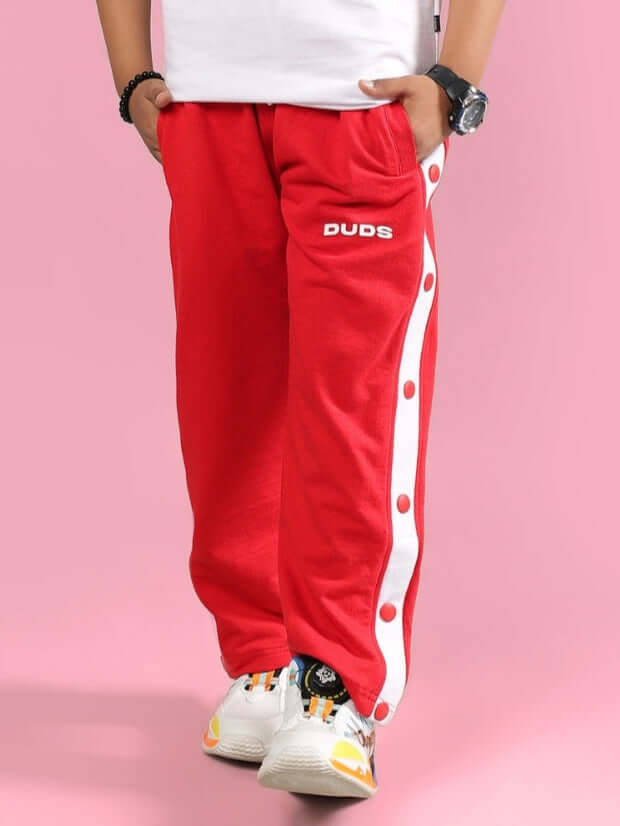 Red EZEL joggers for boys and girls by DUDS, featuring a white side stripe and comfortable design. Perfect for casual wear.