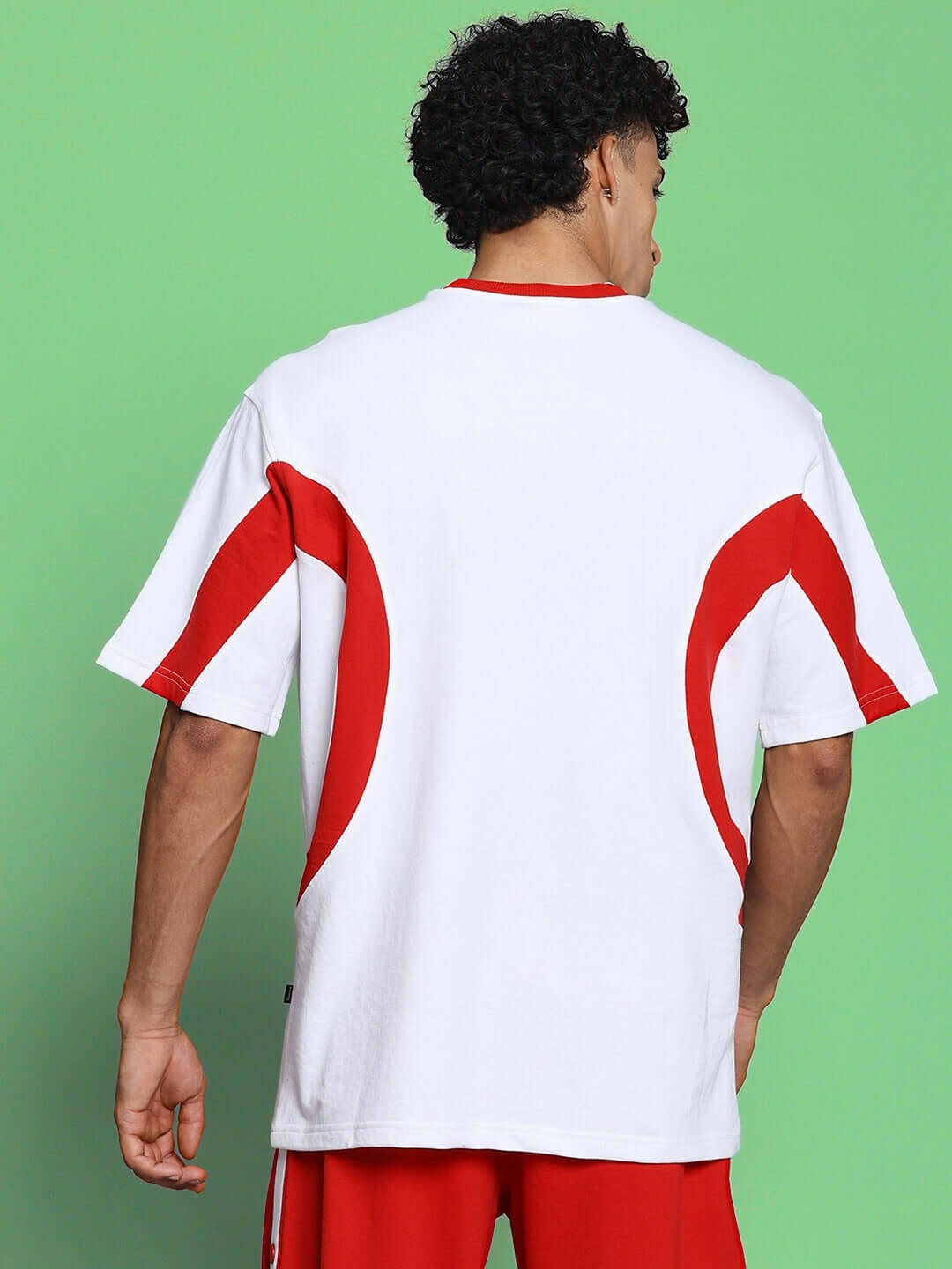 Back view of EZEL OVER-SIZED T-SHIRT WHITE RED worn by a model, showcasing its bold streetwear style and premium cotton fabric.