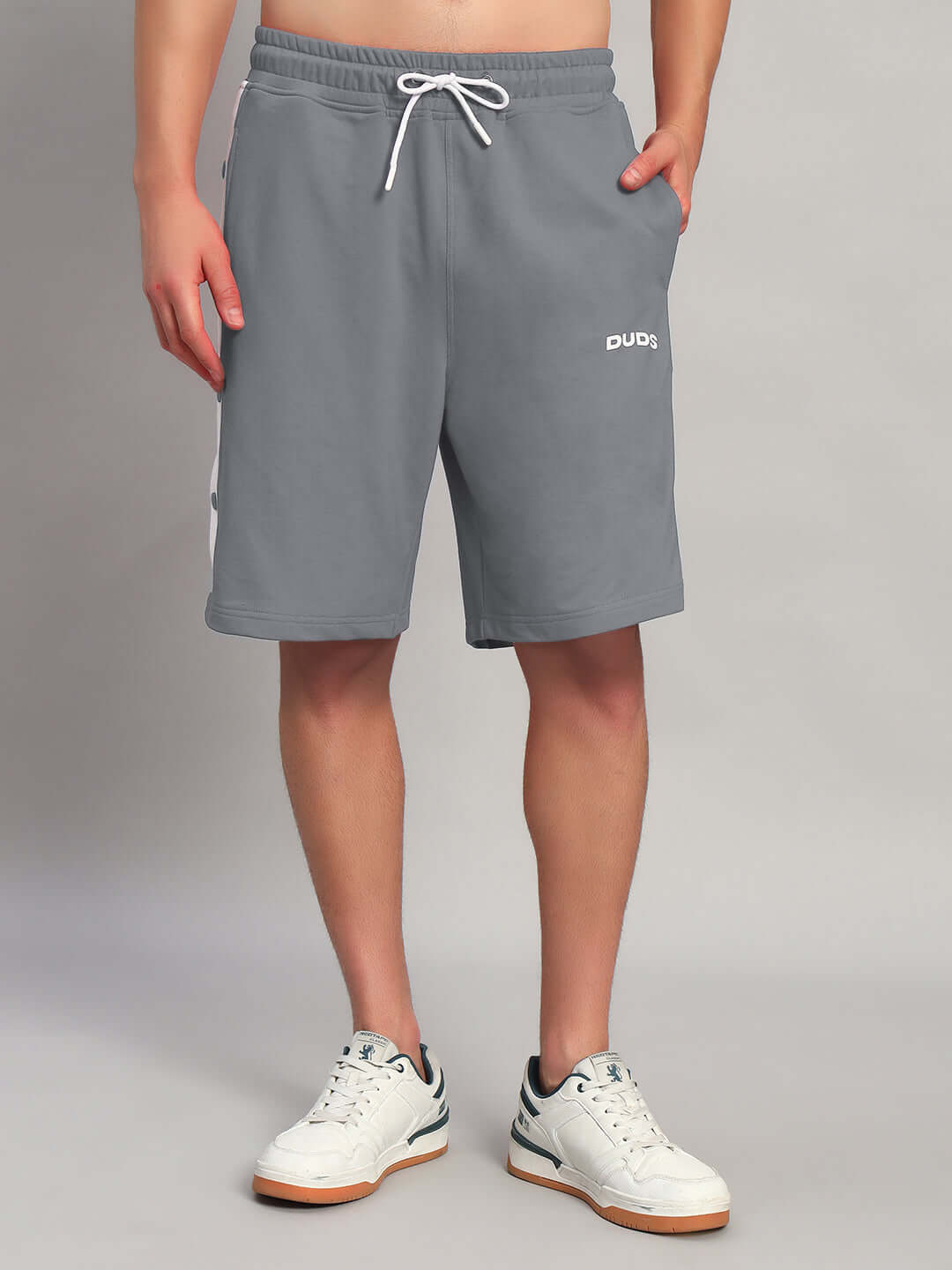 Man wearing EZEL REGULAR FIT COTTON SHORTS GREY with white sneakers, showcasing casual and comfortable style for everyday wear.