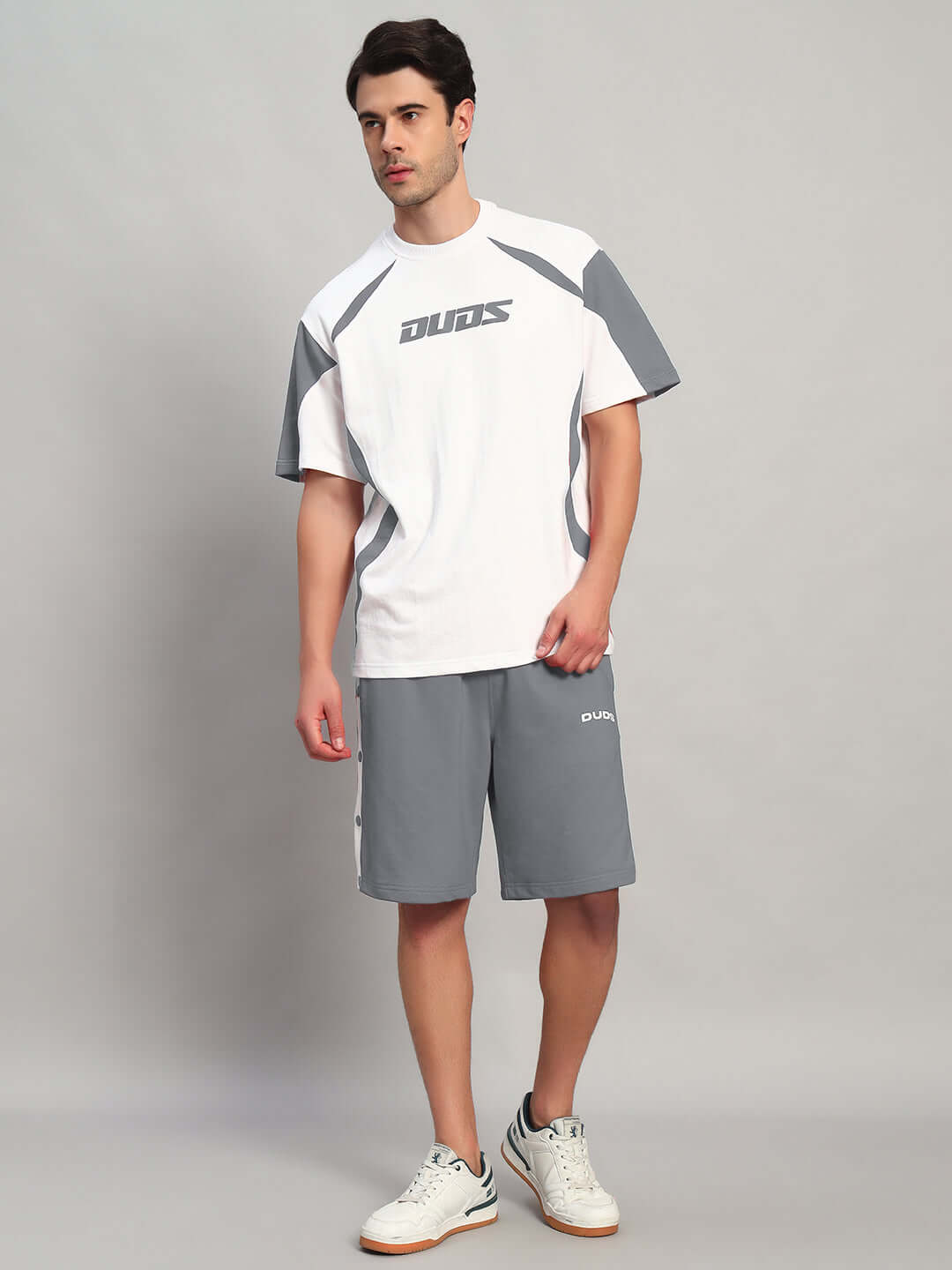 Model wearing EZEL REGULAR FIT COTTON SHORTS GREY paired with a white sporty T-shirt, showcasing casual style.
