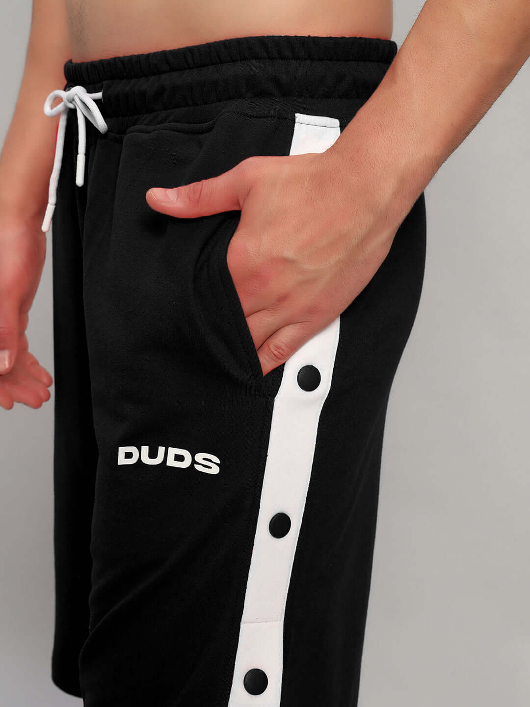 Close-up of person wearing Ezel Regular Fit Shorts Black by WEAR DUDS, showcasing stylish design and breathable cotton fabric.