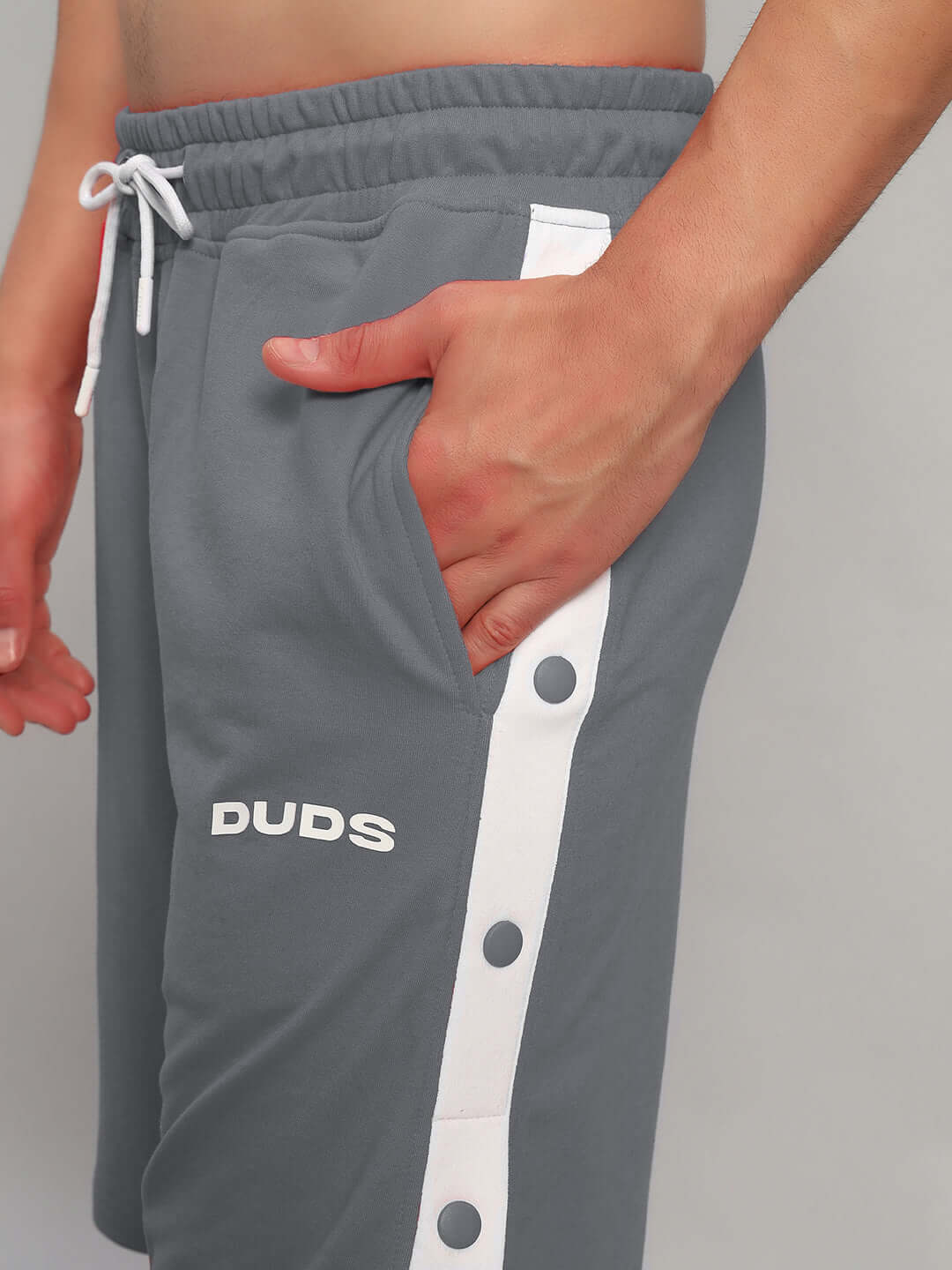 Side view of EZEL REGULAR FIT COTTON SHORTS GREY with white stripe detail, showcasing pocket and relaxed fit design.