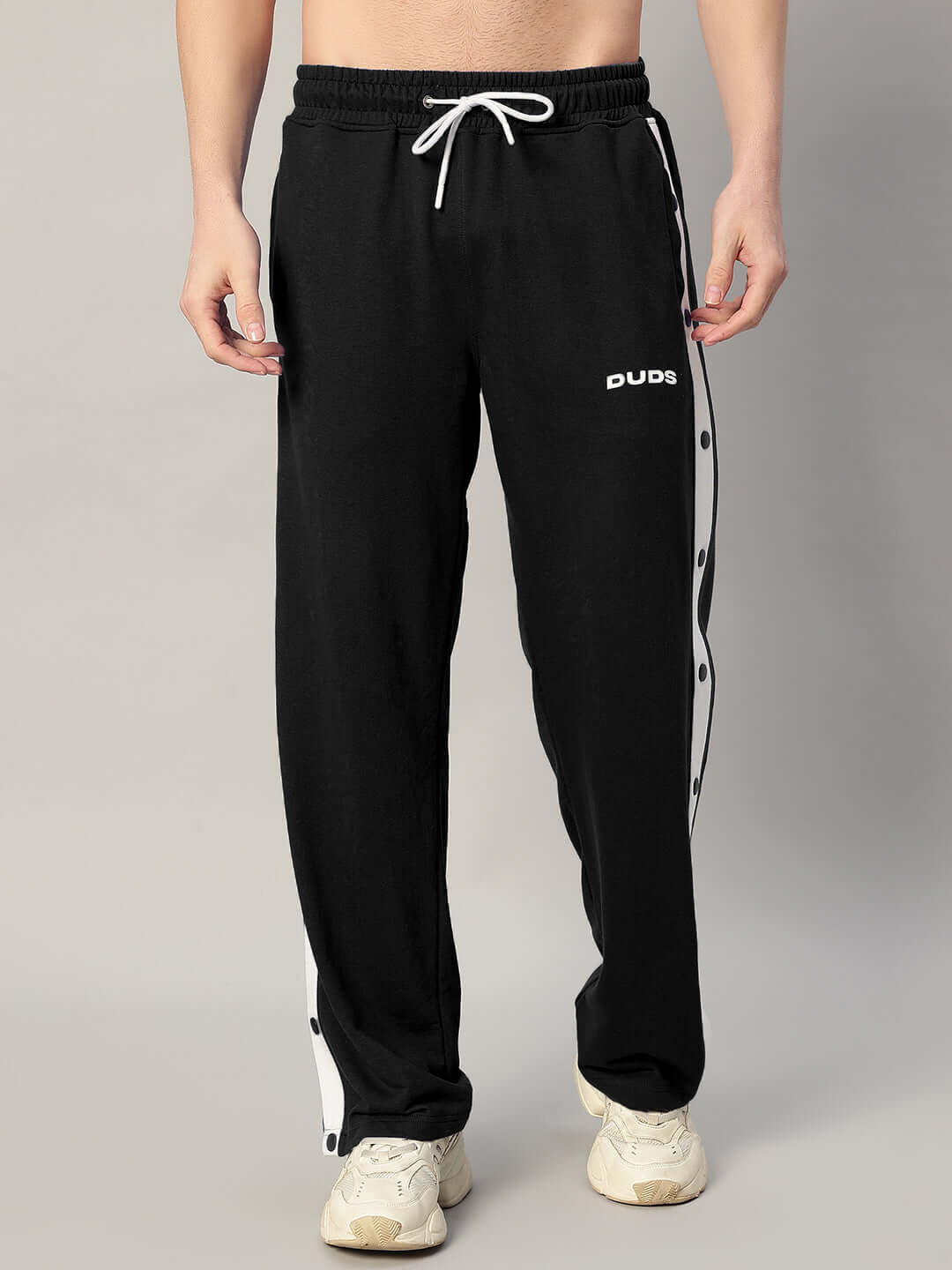 Man wearing EZEL Relaxed Fit Jogger in black by DUDS, featuring a drawstring waist and side stripes, perfect for custom fit orders.