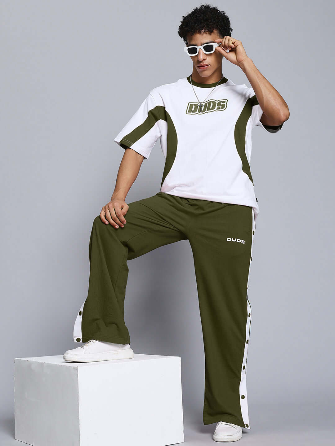 Model wearing EZEL RELAXED FIT CO-ORD SET WHITE-OLIVE with stylish sunglasses and white sneakers.