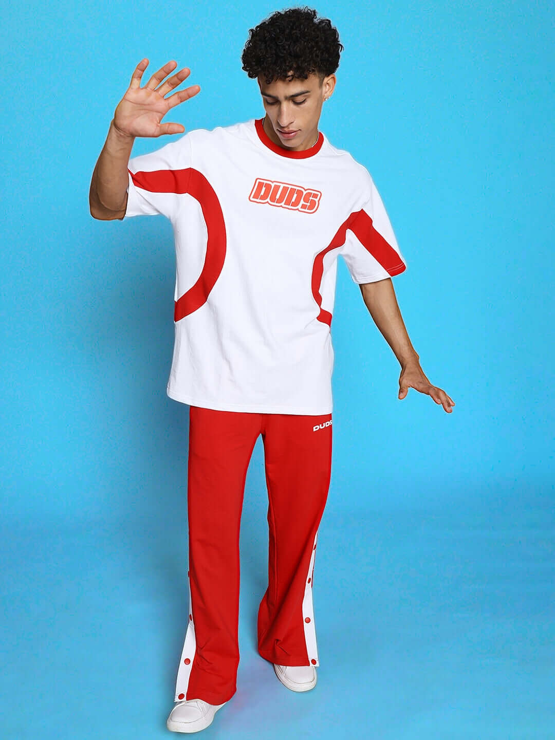 Child wearing EZEL RELAXED FIT CO-ORD SET WHITE-RED, showcasing stylish red and white outfit against a blue background for comfort and play.