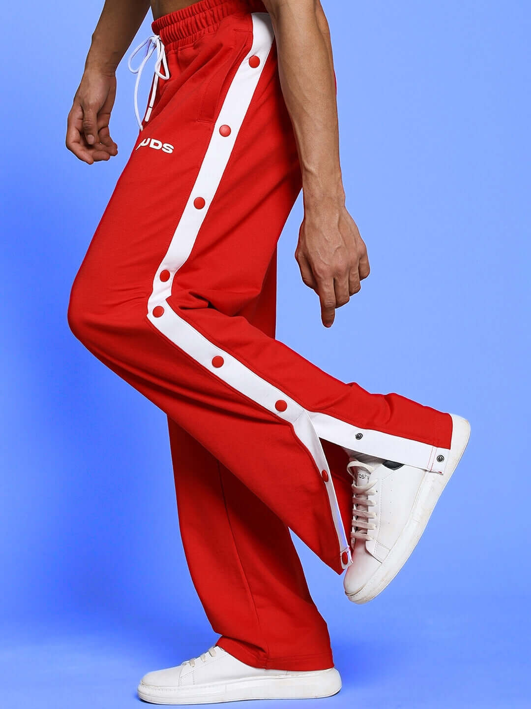 Red EZEL Relaxed Fit Jogger by DUDS with white accents, worn with white sneakers, customizable fit option available.